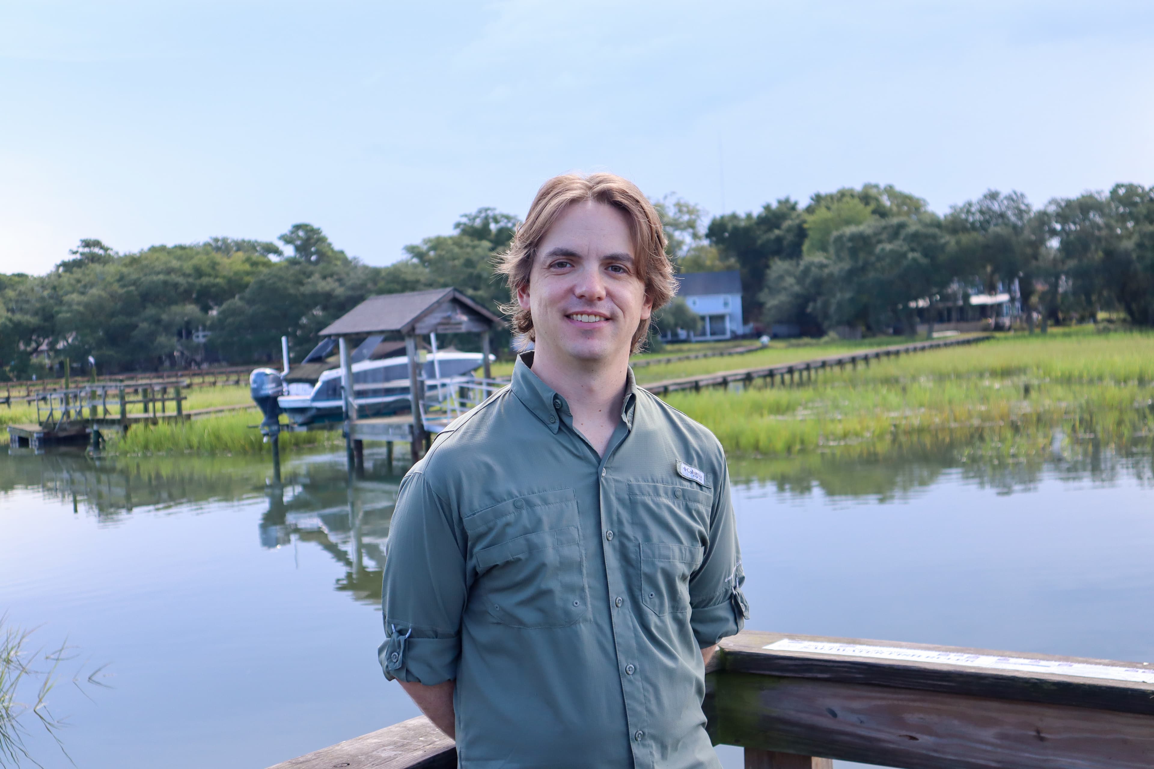 Jackson Bucher, veterinary sonographer, standing beside a marsh
